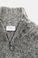 Nahaufnahme aus schräger Draufsicht des graumelierten 04651/ A trip in a bag Troyer 'Gritty' mit Mix aus Baumwolle und Alpakawolle, weichem Griff, voluminösem Strickbild, Regular Fit, hohem Rippstrickkragen mit Zipper und breiten Rippbündchen.