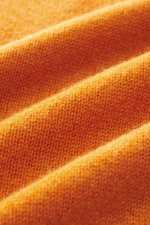 Close-up front view of fine knit pattern in bright orange fabric showing texture and softness of 04651/ A trip in a bag Cashmere quarter-zip jumper 'Extreme' orange, made of pure cashmere with very soft feel, slim fit, sweater collar with zipper, and flex