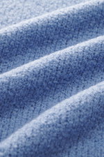 Nahaufnahme der weichen Bouclé-Struktur des 04651/ A trip in a bag Troyer 'Molly' rauchblau, fotografiert in Detail-Perspektive.
