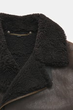 Nahaufnahme der Belstaff Lammfelljacke 'Buxton Phoenix' braun, frontal mit edlem Lammfellkragen, Rindslederbesatz und robustem Reißverschluss.