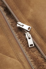 Nahaufnahme des Arma Lammfellblouson 'Arek' braun mit geöffnetem Zwei-Wege-Reißverschluss, zeigt weiches Lammfell und Veloursleder.