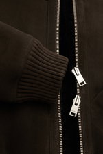 Close-up front view of the Arma Shearling blouson 'Arek' dark brown showing fine lambskin suede, ribbed knit cuff, and two-way zip with ARMA engraving.