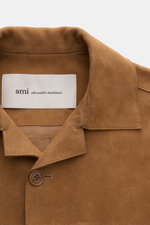 Nahaufnahme aus frontaler Perspektive des Ami Paris Veloursleder-Overshirt camel mit softem Veloursleder, kurzem Reverskragen und Knopf.