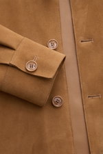 Nahaufnahme aus schräger Vogelperspektive des Ami Paris Veloursleder-Overshirts camel mit softem Veloursleder, Fünf-Knopf-Leiste und Sportmanschette.