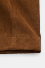 Nahaufnahme der braunen Tom Ford Velourslederjacke, Detailansicht des weichen Rindsveloursleders mit sichtbarer Naht in Slim Fit, frontal fotografiert.