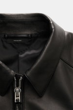 Nahaufnahme der Tom Ford Lederjacke schwarz von oben, zeigt Umlegekragen, robusten Reißverschluss und edles Lammleder mit softem Griff.
