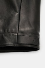 Nahaufnahme der Tom Ford Lederjacke schwarz, Fokus auf Ärmel mit Druckknopfverschluss, edles Lammleder, softer Griff, Slim Fit, robust.