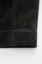 Close-up side view of Tom Ford Velourslederjacke schwarz showing fine black suede leather, detailed stitching, and adjustable waist strap.