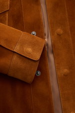 Close-up front view of Tom Ford Suede jacket brown in finest calfskin, showing patch flap pocket, snap buttons, and glossy lining.