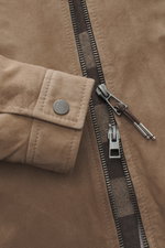 Nahaufnahme der Windsor Velourslederjacke 'Attilio' taupe von vorne mit Fokus auf feines Veloursleder, Umlegekragen, Zwei-Wege-Reißverschluss, schräge Hüfttaschen, Regular Fit, geschmeidiges Innenfutter und zwei Innentaschen.