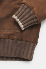 Nahaufnahme des Fedeli Veloursleder-Blouson 'Verbier' graubraun von schräg oben, Detail des weichen Veloursleder-Ärmelbündchens mit Cashmere-Strickabschluss.
