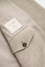 Nahaufnahme des Rifugio Veloursleder-Sakko sand, Detail vom Ärmel mit Knopf und Label, geschmeidiges Veloursleder und weiches Schurwollfutter.