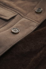 Nahaufnahme der Rifugio Lammleder-Jacke graubraun aus Veloursleder mit Detailansicht der Knöpfe und weichen Lammfell-Innenseite.