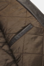 Close-up inside view of the Windsor Leather jacket 'Bassano' dark brown showing its quilted lining, soft leather, and inner pockets from a top angle.