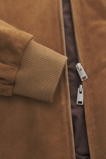 Close-up front view of Arma Suede leather blouson 'Didier' brown showing fine goat suede, elastic rib knit cuffs, and robust two-way zipper.

Description:  
<p>Smart and timeless: The blouson 'Didier' by ARMA is made from supple goat suede and impresses w