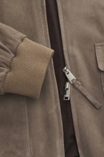 Nahaufnahme des Arma Veloursleder-Blouson 'Gwenno' taupe von schräg vorne mit feinem Veloursleder, Regular Fit, Umlegekragen, robustem Zwei-Wege-Reißverschluss, aufgesetzten Hüfttaschen, elastischen Rippstrickbündchen und geschmeidigem Futterstoff.