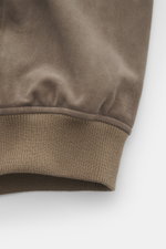 Nahaufnahme des Arma Veloursleder-Blouson 'Gwenno' taupe Ärmels von unten mit elastischen Rippstrickbündchen, feinem Veloursleder, Regular Fit, Umlegekragen, robustem Zwei-Wege-Reißverschluss, aufgesetzten Hüfttaschen und geschmeidigem Futterstoff.