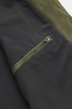 Close-up from above of the dark green Arma Suede leather jacket 'Kale' showing soft suede leather, smooth lining, and zippered inside pocket.