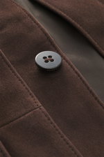 Nahaufnahme der dunkelbraunen 04651/ A trip in a bag Nubuklederjacke 'Workwear Jacket' mit weichem Nubukleder und Knopf, seitliche Perspektive.