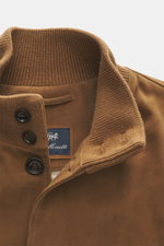 Nahaufnahme des hellbraunen Eddy Monetti Veloursleder-Blousons von schräg oben, zeigt Stehkragen aus Rippstrick, Acht-Knopf-Leiste, schmales Slim Fit und weiches Cashmere-Futter.