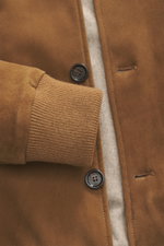 Nahaufnahme aus seitlicher Perspektive des Eddy Monetti Veloursleder-Blouson hellbraun mit Acht-Knopf-Leiste, Rippstrick-Bündchen und wärmendem Cashmere-Futter.