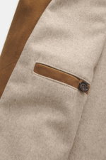 Nahaufnahme des Eddy Monetti Veloursleder-Blouson hellbraun aus geschmeidigem Veloursleder, Detailansicht einer paspelierten Hüfttasche mit Knopf, stehend fotografiert.