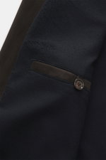 Nahaufnahme des Eddy Monetti Veloursleder-Blouson dunkelbraun von schräg oben, zeigt paspelierte Hüfttasche mit Knopf, Rippstrickkragen, Cashmere-Futter.