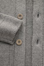Nahaufnahme des 04651/ A trip in a bag Cardigan 'Boiled Blouson' grau meliert mit mittelfeinem Strick, sechs Knöpfen und Rippbündchen aus Woll-Mix.
