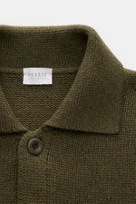 Nahe Aufnahme des olivfarbenen 04651/ A trip in a bag Cardigan 'Boiled Blouson' mit Umlegekragen, sechs Knöpfen, dickem Woll-Mix-Strick.