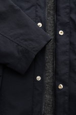 Nahaufnahme des 04651/ A trip in a bag Parka 'The Triple' navy von vorne, zeigt Reißverschluss, Druckknöpfe und leicht strukturierte Microfaser.