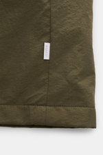 04651/ A trip in a bag Parka 'The Triple' oliv aus hochwertiger Microfaser mit Logo-Weblabel an der Seitennaht, Detailaufnahme des Saums.