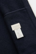 Close-up inside view of the Lunaria Cashmere Cashmere Jacke navy showing navy blue pure cashmere fabric and brand label, highlighting its soft, unfuttered, slim fit design with two-way zipper, hood, elastic cuffs, and side seam pockets. Puristischer Luxus