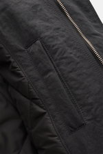 Nahaufnahme des Ami Paris Parka anthrazit von schräg oben, zeigt wind- und wasserabweisende Crinkle-Serge-Qualität mit Leistentasche und Teil des Zwei-Wege-Reißverschlusses.