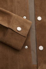 Nahaufnahme der Ami Paris Velourslederjacke hellbraun von vorne, feinstes Veloursleder, Druckknopfleiste, Manschettenärmel, regulierbare Taillenriegel, ungefüttert.