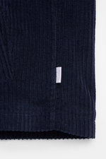 Nahaufnahme der unteren Kante der 04651/ A trip in a bag Cordjacke navy aus elastischer Baumwolle mit weichem Griff und Label seitlich.