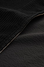 Nahaufnahme der schwarzen 04651/ A trip in a bag Cordjacke mit Metall-Reißverschluss, weichem Griff und tonalem Futterstoff.