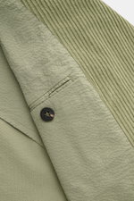 Nahaufnahme der Innenseite und des Revers der 04651/ A trip in a bag Cord-Cabanjacke salbei aus voluminösem Breitcord und Seersucker-Futter.