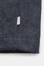 Nahaufnahme des unteren Saums vom 04651/ A trip in a bag Blouson navy meliert im Denim-Look mit weißem Weblabel in der Seitennaht.