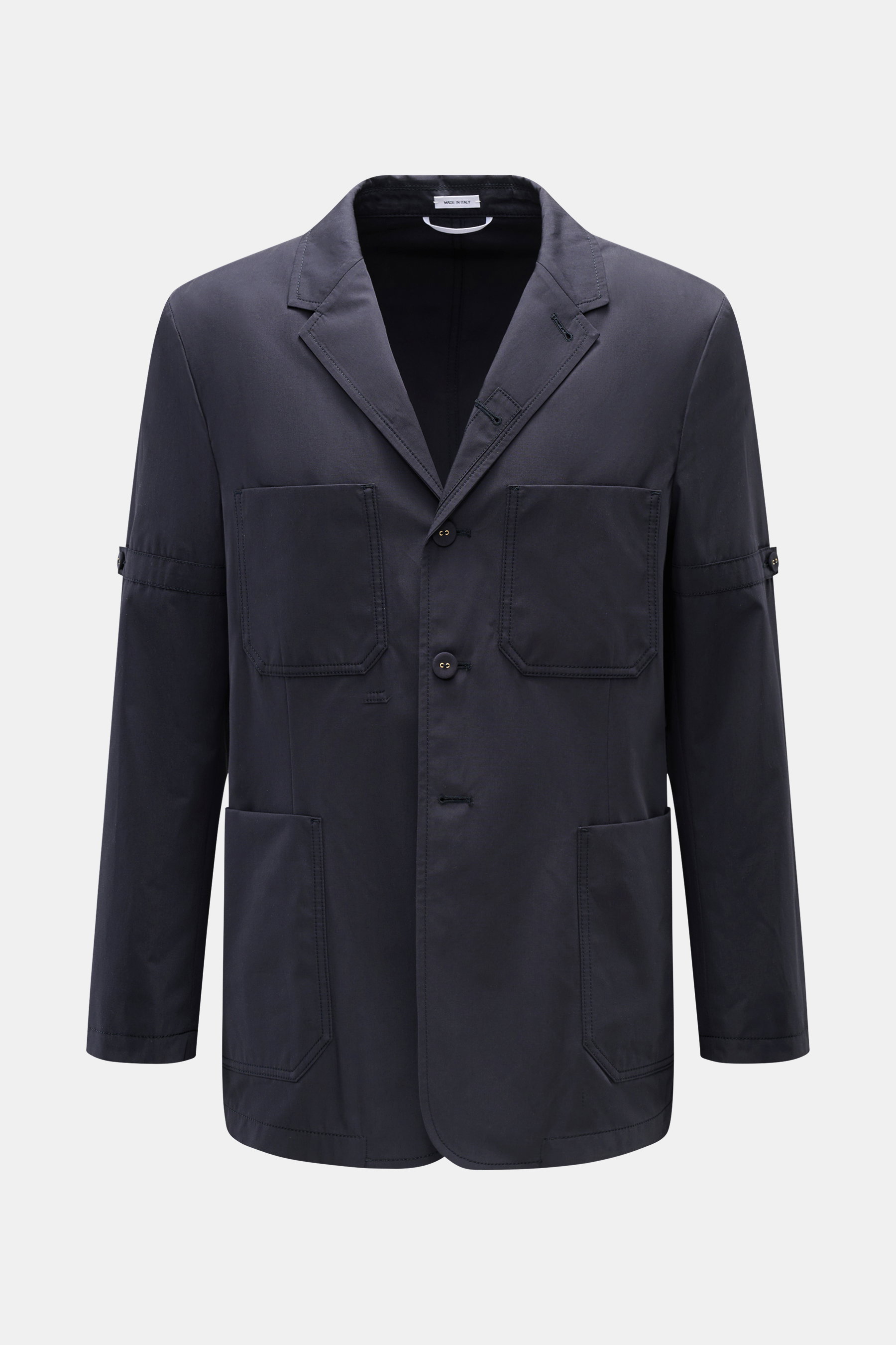 Frontale Aufnahme der Thom Browne Jacke navy aus reiner Baumwolle, Slim Fit mit vier Knöpfen, variabler Kragen, vier Fronttaschen, Kissing Buttons an den Ärmelabschlüssen und rückwärtigem Taillenriegel.