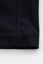 Nahaufnahme der strukturierten Baumwolloberfläche einer Thom Browne Jacke navy, Detail des unteren Saums, Regular Fit, atmungsaktiv.