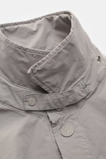 Stone Island Jacke 'Ghost Piece' hellgrau, Nahaufnahme von Umlegekragen mit Knopfriegel, Druckknopfleiste und hochwertiger Microfaser, softer Griff.