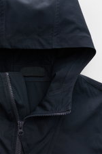 Nahaufnahme der Stone Island Jacke 'All-Weather S.I. Ghost Piece' navy aus Baumwollcanvas mit Kapuze, Reißverschluss und glattem Griff.