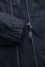 Nahaufnahme der Stone Island Jacke 'All-Weather S.I. Ghost Piece' navy von vorne, mit robustem Zwei-Wege-Reißverschluss und elastischem Ärmelabschluss aus dicht gewebtem Baumwollcanvas, wind- und wasserabweisend, Slim Fit, Kapuze, Fronttaschen mit Patte u