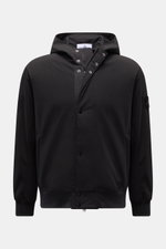 Front view of Stone Island Blouson 'Light Soft Shell-R' black, a slim fit soft shell jacket with drawstring hood, zip front, and compass badge. Style meets function: This soft shell jacket by STONE ISLAND has a sporty design in three-layer functional mate