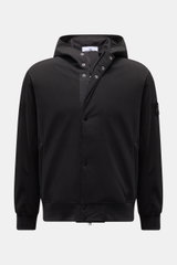 Front view of Stone Island Blouson 'Light Soft Shell-R' black, a slim fit soft shell jacket with drawstring hood, zip front, and compass badge. Style meets function: This soft shell jacket by STONE ISLAND has a sporty design in three-layer functional mate