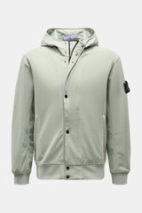 Front view of Stone Island Blouson 'Light Soft Shell-R' salbei in sage green, featuring a hood with drawstring, two-way zipper, snap wind flap, zipper pockets, elastic cuffs and hem, mesh lining, and compass badge on the upper arm. 

<p>Stil trifft Funkti