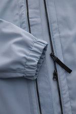 Close-up front view of Stone Island Jacke 'Light Soft Shell-R' rauchblau showing elastic sleeve cuff, two-way zipper, and smooth microfiber fabric with wind- and water-resistant properties.
