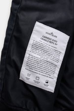 Nahaufnahme des Innenfutters mit weißem Stoffetikett des Stone Island Blouson 'Garment Dyed Crinkle Reps NY' navy aus hochwertiger Microfaser.