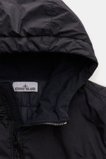 Close-up front perspective of the Stone Island Jacket 'Garment Dyed Crinkle Reps NY' dark navy, showing the lightweight microfibre fabric with a creased effect from resin coating and the padded hood with zipper. Function meets style: This sporty jacket by