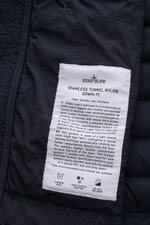Close-up interior view of Stone Island Daunenjacke 'Seamless Tunnel Nylon Down-TC' dark navy label showing fabric research details and care icons.